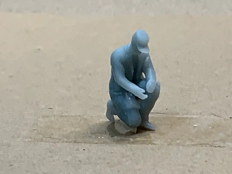 Man Kneeling Long Coat Cap 1